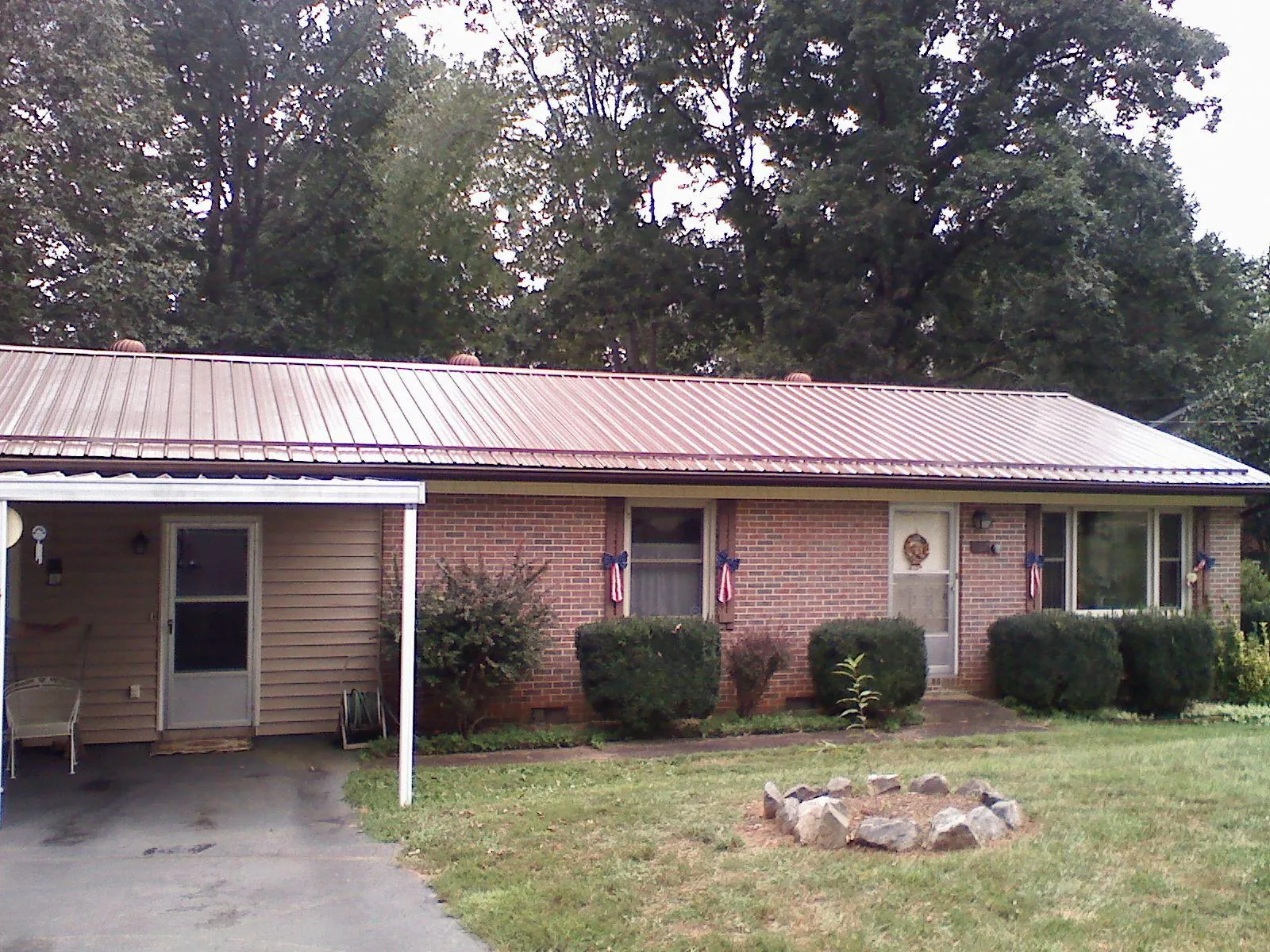Bronze metal roof and carport on a brick ranch home — Roof Repair work by our crew in Arbovale